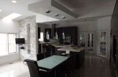 Spacious modern kitchen and dining area with dark cabinetry and a large island.
