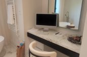 a bathroom with a marble counter top and a large mirror