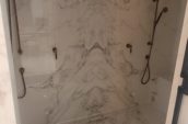 a walk in shower sitting inside of a bathroom