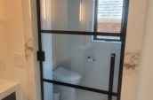 a bathroom with a toilet and a glass door