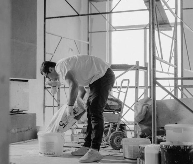 man-in-white-t-shirt-and-black-pants-holding-plastic-bag